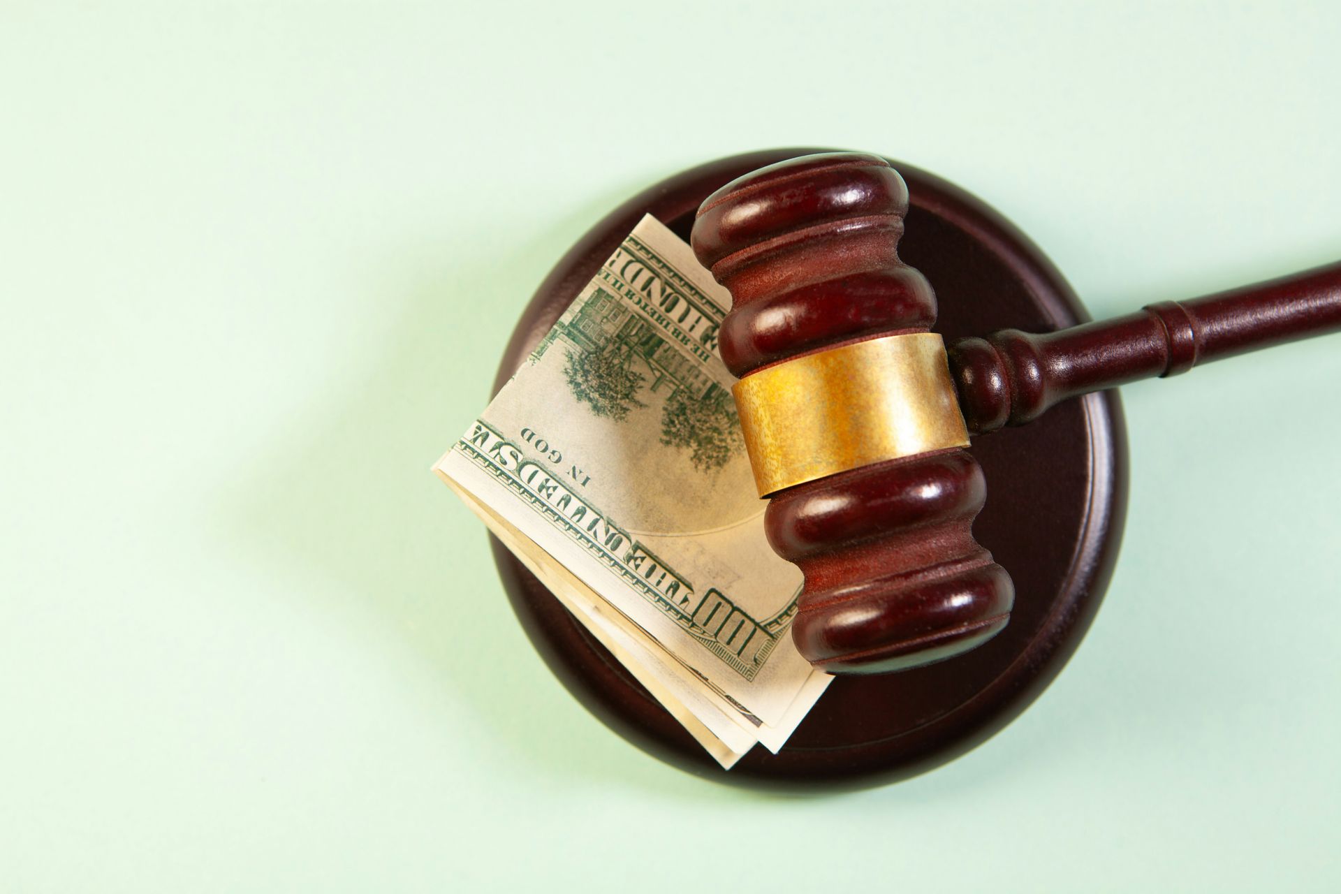 A gavel rests on a sound block with money